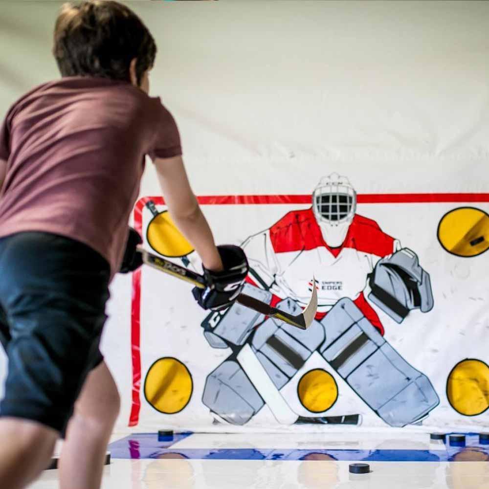 A boy practicing using his hockey shooting tarp 